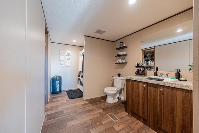 bathroom with vanity, hardwood / wood-style flooring, a textured ceiling, and toilet