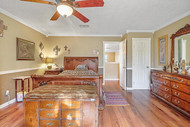 bedroom featuring a textured ceiling, ceiling fan, wood-type flooring, and ornamental molding