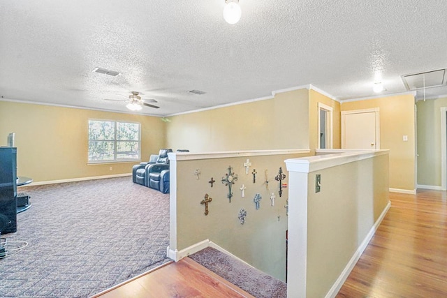 interior space with wood-type flooring, a textured ceiling, and crown molding