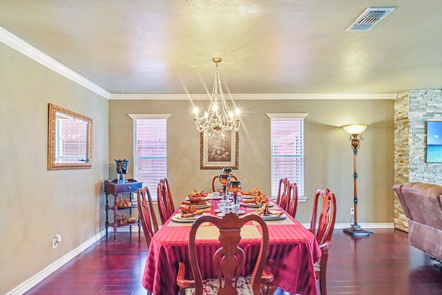 dining area with ornamental molding, dark wood-type flooring, and an inviting chandelier