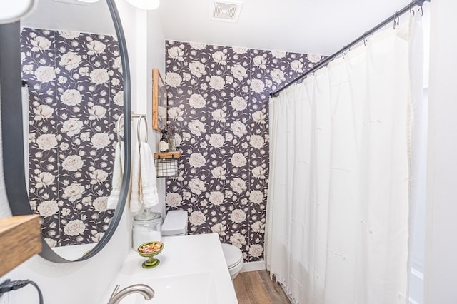 bathroom with hardwood / wood-style flooring and toilet