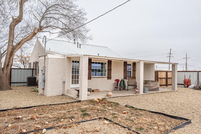 back of property with a storage unit and a patio area