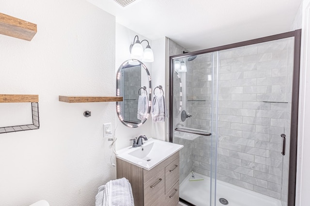 bathroom with vanity and a shower with shower door