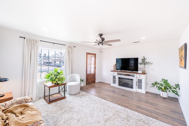 living room with wood-type flooring and ceiling fan