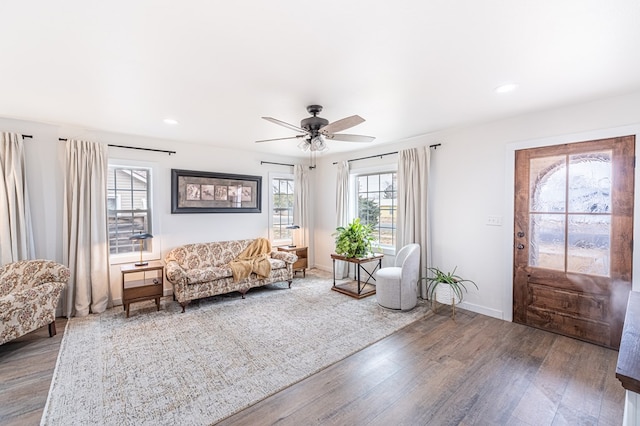 living area featuring dark hardwood / wood-style flooring and ceiling fan