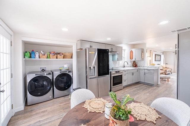 kitchen with sink, gray cabinetry, light hardwood / wood-style floors, stainless steel appliances, and washer and clothes dryer