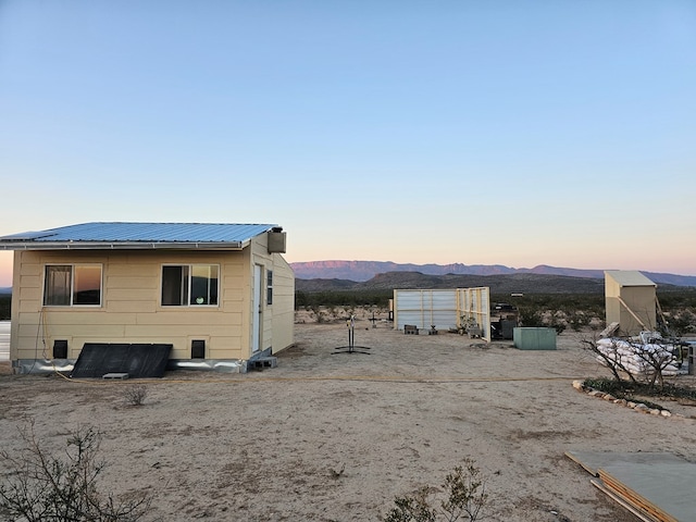 property exterior at dusk with a mountain view