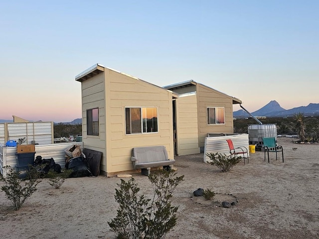 back house at dusk featuring a mountain view