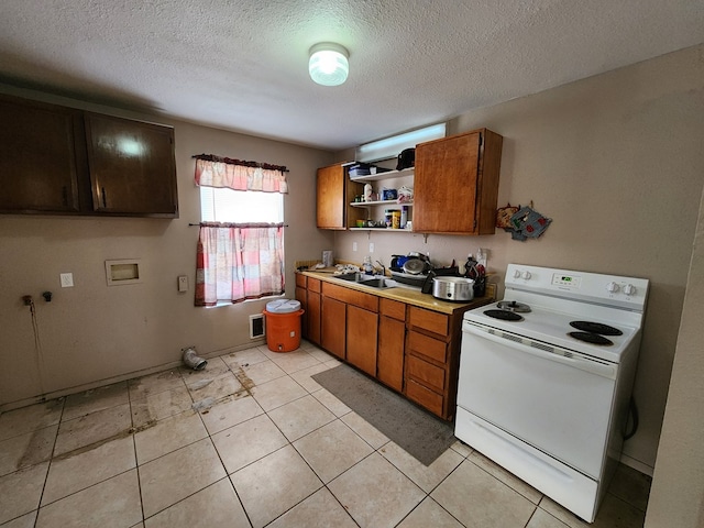 kitchen with open shelves, white range with electric cooktop, light countertops, brown cabinetry, and a sink