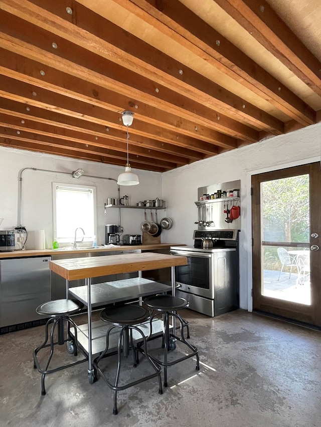 kitchen featuring pendant lighting, sink, concrete floors, beam ceiling, and stainless steel appliances