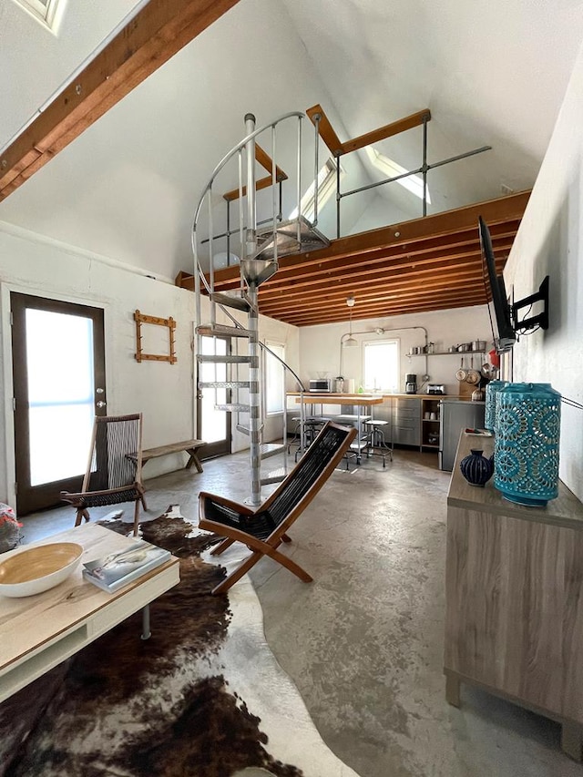 interior space featuring a healthy amount of sunlight, a towering ceiling, and concrete floors