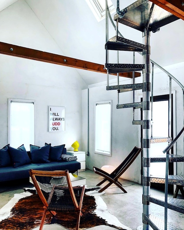 interior space featuring concrete floors, vaulted ceiling, and a healthy amount of sunlight