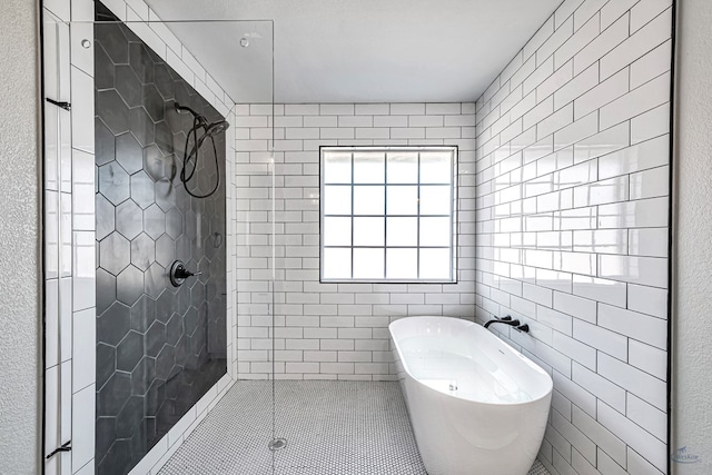 bathroom with tile patterned floors and shower with separate bathtub