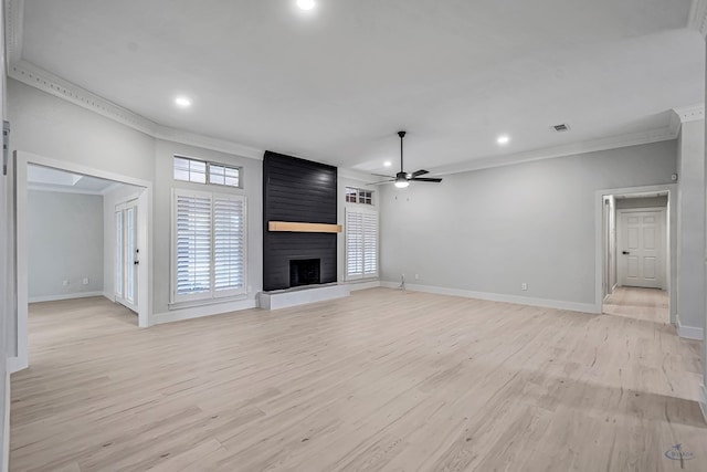 unfurnished living room with ceiling fan, a large fireplace, ornamental molding, and light hardwood / wood-style flooring