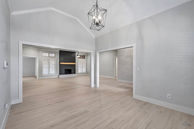 unfurnished living room featuring high vaulted ceiling, crown molding, light hardwood / wood-style floors, a notable chandelier, and a large fireplace