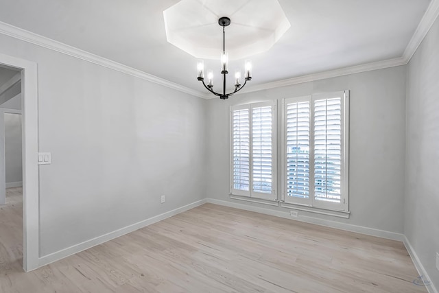 spare room featuring a raised ceiling, light wood-type flooring, crown molding, and a chandelier