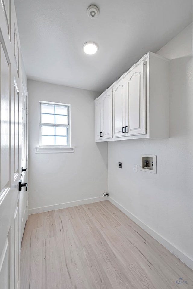 laundry room featuring electric dryer hookup, hookup for a washing machine, cabinets, and light hardwood / wood-style floors