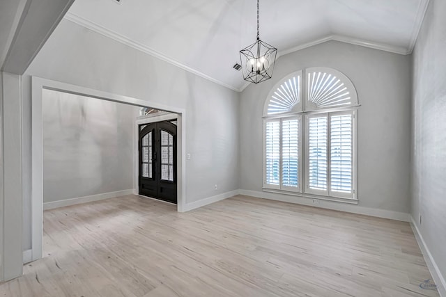 spare room with ornamental molding, french doors, light wood-type flooring, and an inviting chandelier