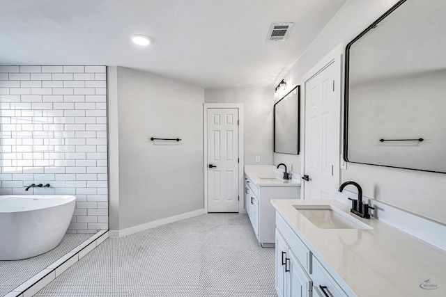 bathroom with tile patterned flooring, vanity, and a tub to relax in