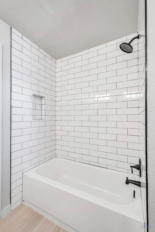 bathroom with tiled shower / bath combo and wood-type flooring