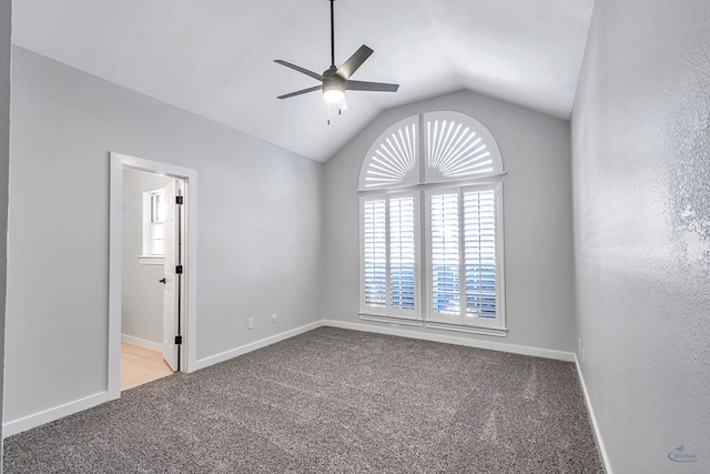 empty room featuring ceiling fan, lofted ceiling, and light carpet