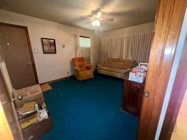 sitting room featuring ceiling fan and dark colored carpet