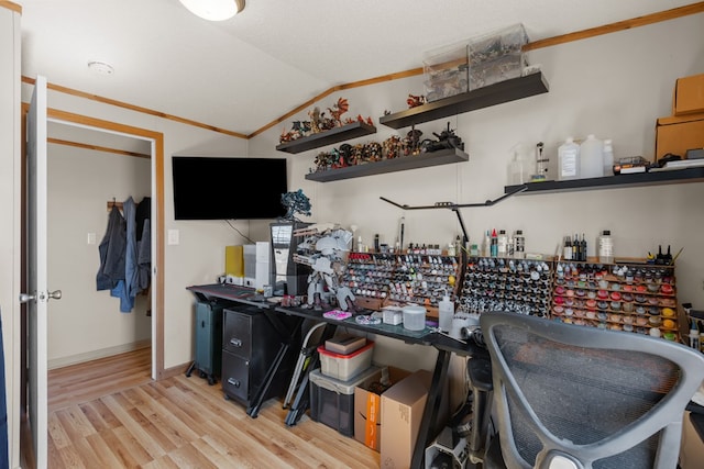 office featuring lofted ceiling, wood finished floors, crown molding, and baseboards