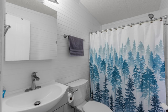 bathroom with a shower with shower curtain, a textured ceiling, vanity, and toilet