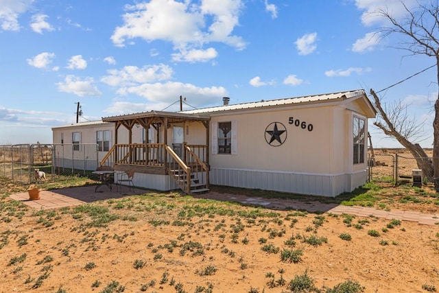 view of front of house with fence and metal roof