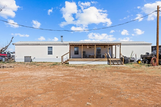 rear view of property featuring covered porch, metal roof, and central AC