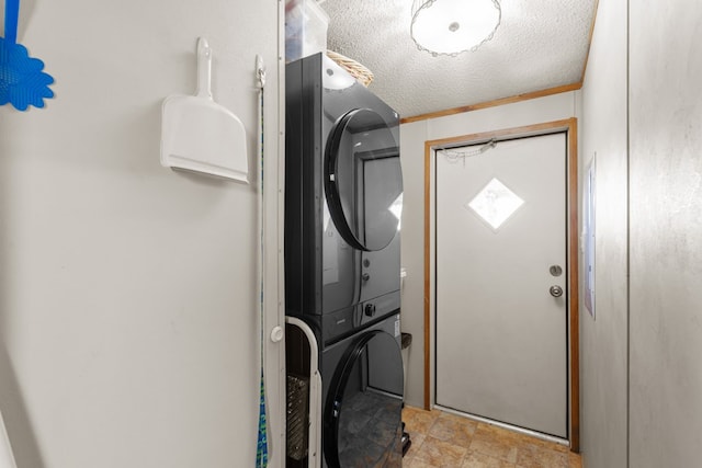 washroom with laundry area, stacked washer and clothes dryer, and a textured ceiling