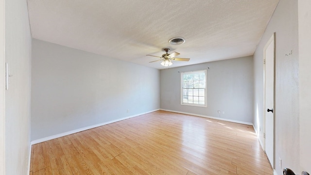 spare room featuring light hardwood / wood-style floors and a textured ceiling