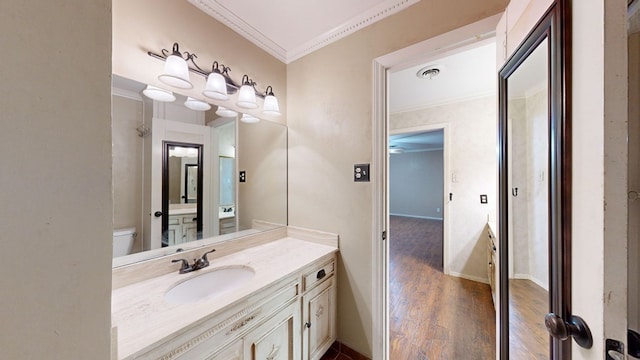 bathroom featuring hardwood / wood-style floors, vanity, toilet, and ornamental molding