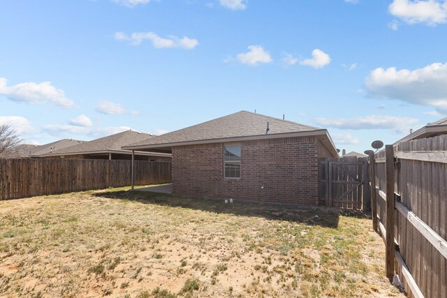 view of yard featuring a fenced backyard and a gate