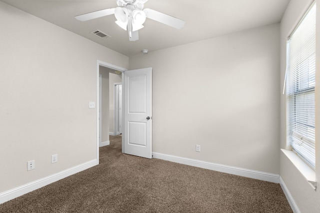 spare room featuring visible vents, baseboards, a ceiling fan, and carpet flooring