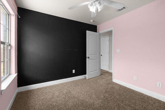 unfurnished room featuring a ceiling fan, carpet flooring, baseboards, and visible vents