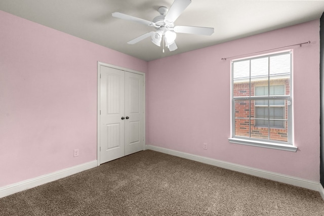 unfurnished bedroom with baseboards, carpet floors, a closet, and ceiling fan