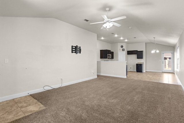 unfurnished living room featuring visible vents, ceiling fan with notable chandelier, light tile patterned floors, light colored carpet, and vaulted ceiling