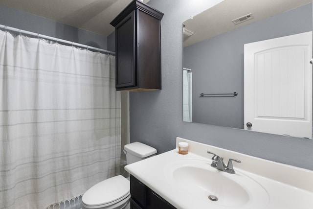 full bath with vanity, a shower with shower curtain, visible vents, toilet, and a textured wall