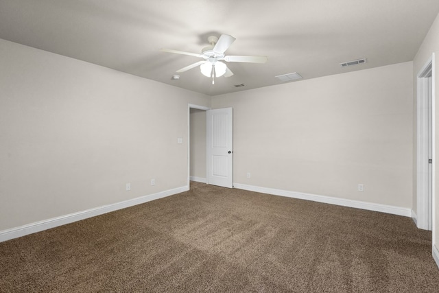 empty room with baseboards, visible vents, dark carpet, and ceiling fan