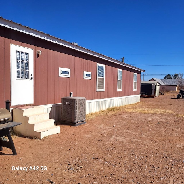 view of side of home with central AC unit