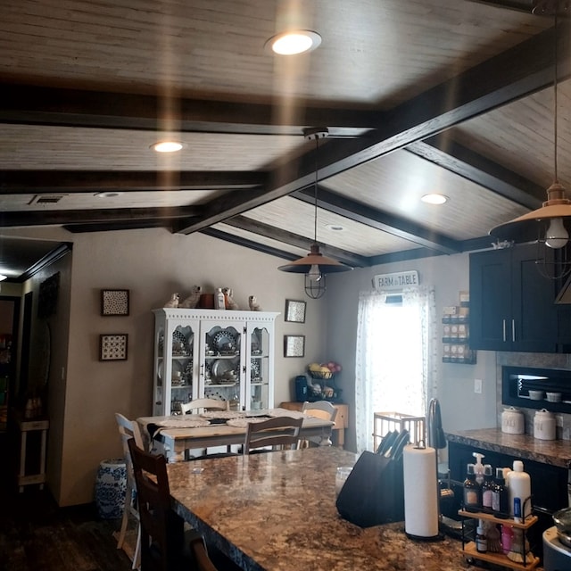 kitchen with blue cabinetry and vaulted ceiling with beams