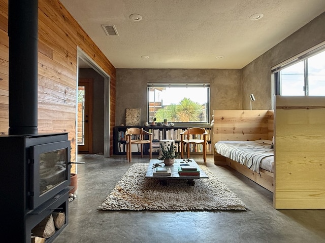 living area featuring a wood stove and a textured ceiling