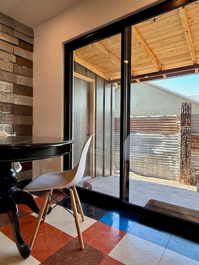 doorway to outside featuring beam ceiling and wooden ceiling