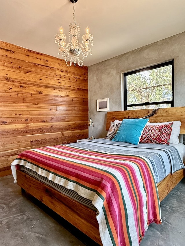 bedroom with wood walls and an inviting chandelier