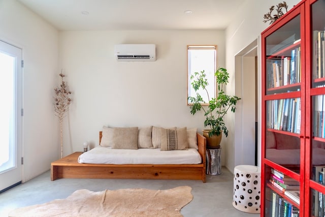 living area with a wall unit AC and a wealth of natural light