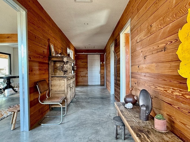 corridor featuring wooden walls