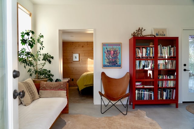 living area featuring wood walls and carpet floors