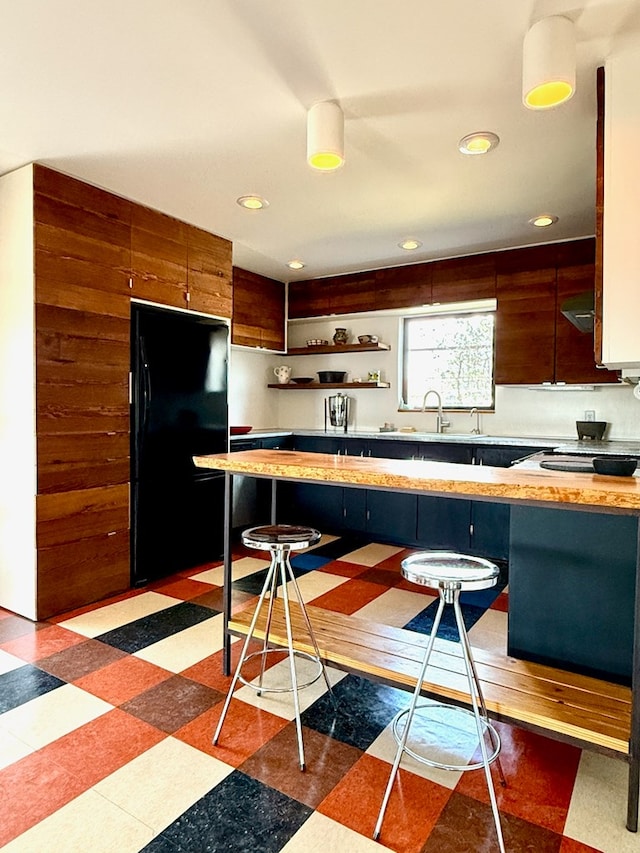 kitchen with a breakfast bar area and black fridge