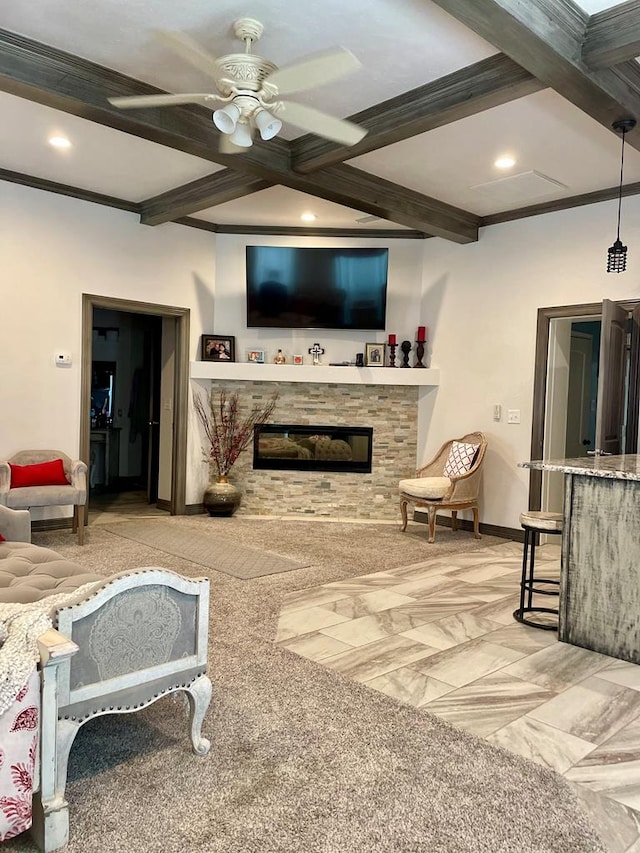 living room with ceiling fan, a stone fireplace, light colored carpet, and crown molding